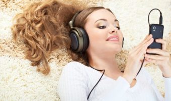 16466483 - smiling woman lying on carpet and listening to music