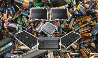 Various car audio amplifiers on top of a pile of various batteries