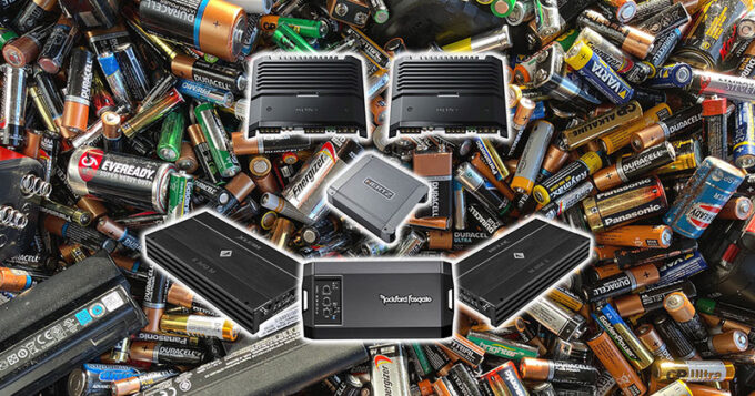 Various car audio amplifiers on top of a pile of various batteries